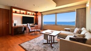 Wohnbereich mit Sofa, Schreibtisch und Meerblickfenster