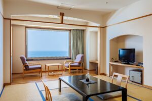 Tatami-Zimmer mit niedrigem Tisch, Stühlen und Fenster mit Meerblick