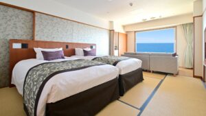 Zwei Betten in einem Tatami-Zimmer mit Blick zum Meeresfenster