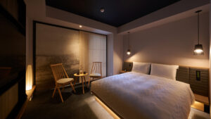 Doppelbett neben einem kleinen Tisch und Stühlen