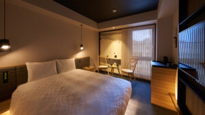 Gästezimmer mit großem Bett und Sitzbereich am Fenster