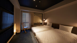 Zwei Betten in einem schwach beleuchteten Gästezimmer