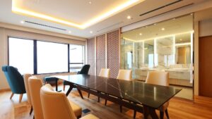 ガラス張りのバスルームエリア横のダイニングテーブルと椅子