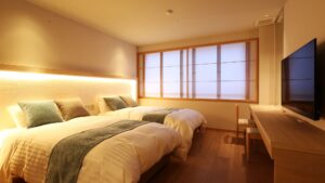 テレビとデスクのある客室のツインベッド
