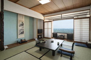 Tatami-Zimmer mit niedrigem Tisch und Stühlen am Fenster