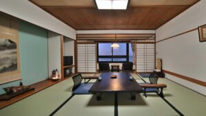 Tatami-Zimmer mit niedrigem Tisch und Sitzplätzen am Boden