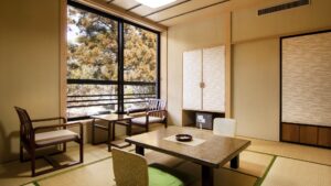 Camera in tatami con tavolo basso, sedie e finestra