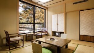 Camera in tatami con tavolo basso, sedie e vista dalla finestra