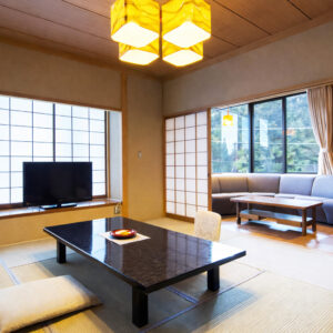 Camera in tatami con tavolo basso, cuscini e divano