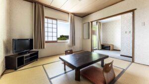 Tatami room with low table, floor chairs, and TV