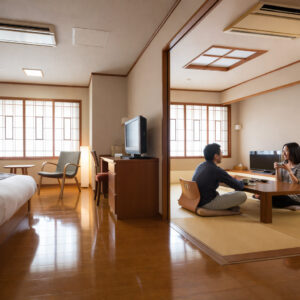 Des clients assis autour d’une table basse dans une chambre en tatami