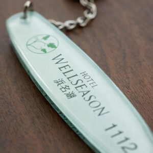 木の表面に置かれたホテルウェルシーズンのルームキーホルダー