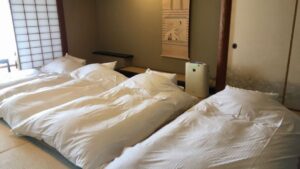 Drei weiße Betten in einem Tatami-Zimmer