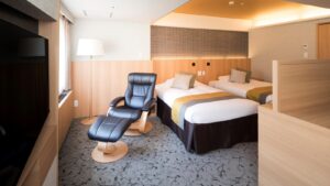 Twin beds with recliner chair in guest room