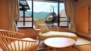 Tatami room seating area by window with mountain view