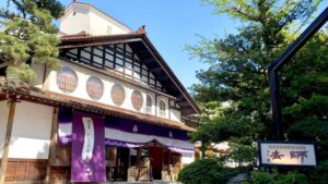 带紫色门帘和树木的日式旅馆入口外观