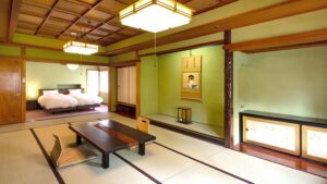榻榻米客房，配有矮桌，后方摆放着床铺