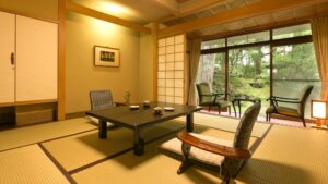 窗边摆有矮桌和椅子的榻榻米客房