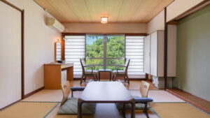 窓際に低いテーブルと椅子がある畳の部屋