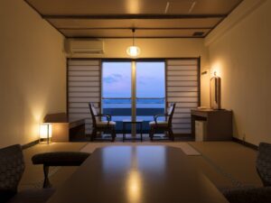 テーブルと椅子、海に面した窓のある畳の部屋