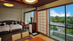 Chambre avec lits et balcon donnant sur la verdure