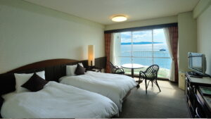 Lits jumeaux près d’une fenêtre avec vue sur la mer