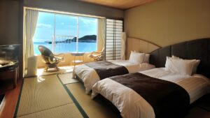 Lits jumeaux dans une chambre en tatami avec balcon vue sur l’océan