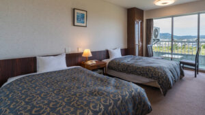 Twin beds in a guest room with balcony view