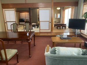 Guest room seating area with chairs, tables, and television