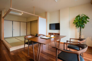 Table and chairs beside raised tatami sitting area