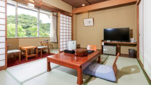 Chambre en tatami avec table basse, chaises et télévision
