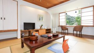 Chambre en tatami avec table basse, chaises de sol et places près de la fenêtre