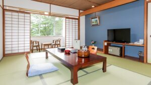 Chambre en tatami avec table basse, coussins de sol et fenêtre
