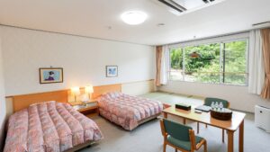 Lits jumeaux dans une chambre avec table et fenêtre