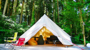 Tienda de glamping con sillas en un claro del bosque
