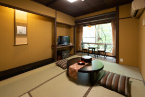 Habitación de tatami con mesa baja y asientos junto a la ventana