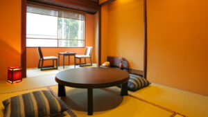 Habitación de tatami con mesa baja, cojines de suelo y sillas
