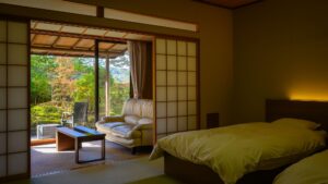 Bett neben Sitzbereich und Gartenblick im Tatami-Zimmer