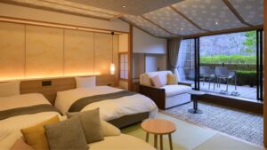 Gästezimmer mit zwei Betten, Sofa und Sitzplätzen auf dem Balkon
