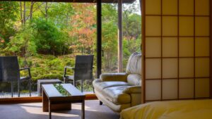 Sofa und Stühle neben dem Fenster mit Blick auf den Garten