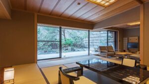 Tatamizimmer mit niedrigem Tisch und Stühlen am Fenster