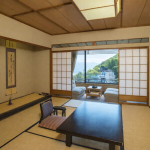 Tatamizimmer mit niedrigem Tisch und Sitzbereich am Fenster