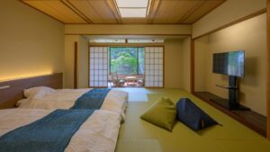 Tatamizimmer mit zwei Betten und Sitzbereich am Fenster