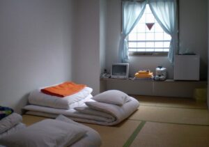 Futons pliés sur le sol en tatami dans la chambre