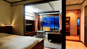 Bedroom with bed, sofa, and balcony view