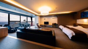 Guest room with twin beds, sofa, and ocean-facing windows