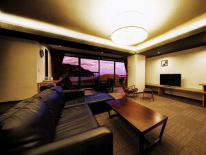 Living area with sofa, table, TV, and balcony view