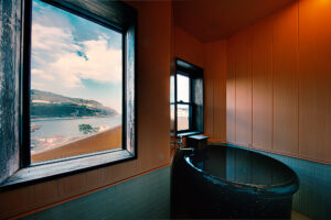 Private bath tub beside windows overlooking the coast