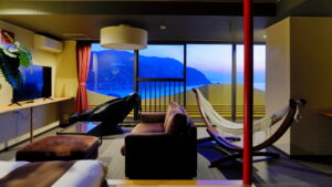 Sofa and hammock seating facing ocean view windows