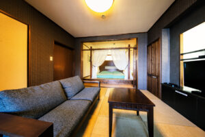 Sofa and table in tatami guest room with bed alcove